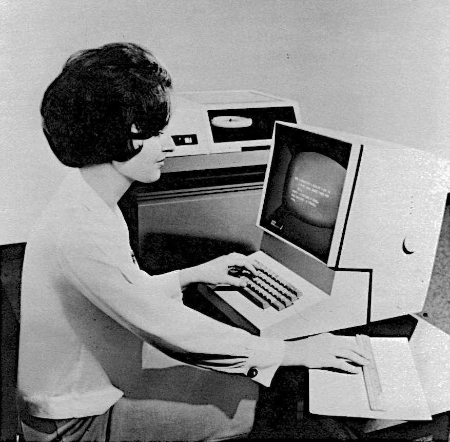 A woman typing on an IBM 2260 terminal.