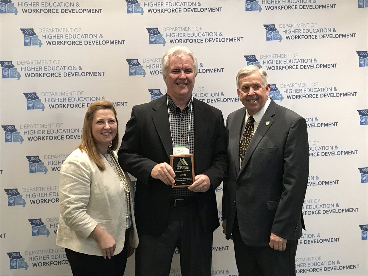 Zora Mulligan, Pat Lynch, and Governor Parson smile with a plaque for Employer of the Year.