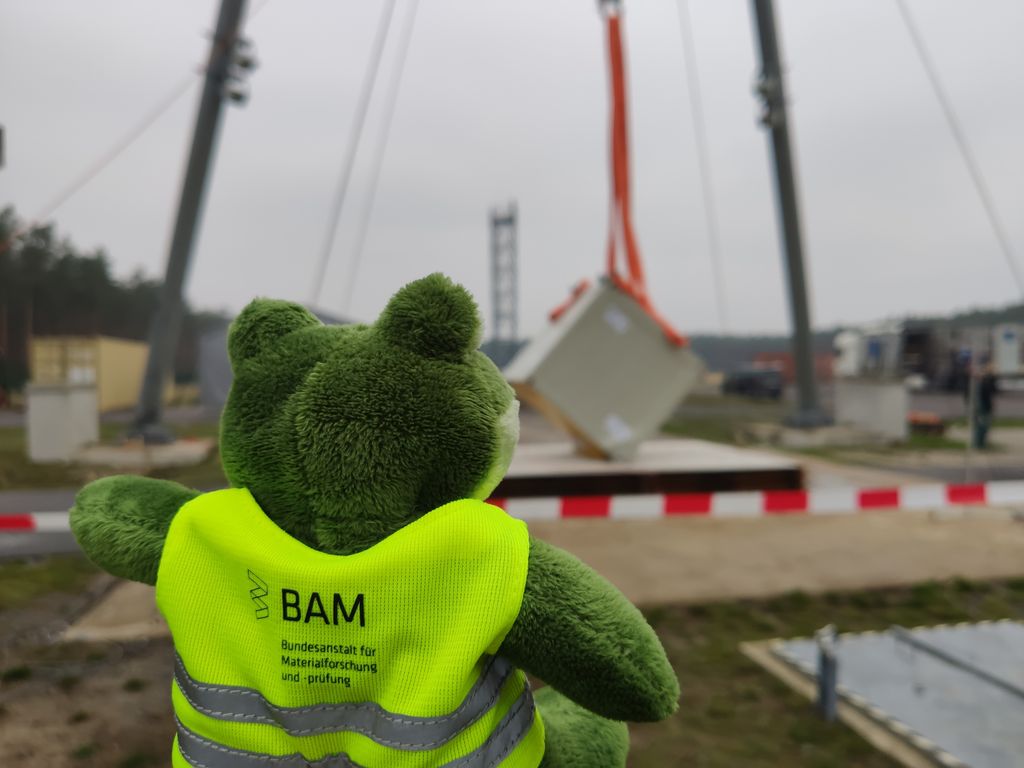 BAMResearch's tweet photo. Bevor dieser Container als Endlagerbehälter für radioaktive Stoffe zum Einsatz kommt, wird er von #BAMResearch begutachtet & muss u.a. Experimente zu Beanspruchungen im Störfall überstehen. Auch #BAMfred schaut sich das Ergebnis des Fallversuches auf dem Testgelände TTS genau an. https://t.co/7xenYkCQX7