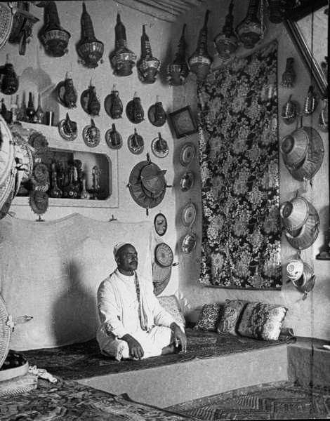 A man sits in his apartment in Harar, Ethiopia 1935. Each level of seating space represents social rank. Younger men will sit on lower levels, while the men who are older and have more social rank in terms of marriage, age, or education will sit at a higher level.