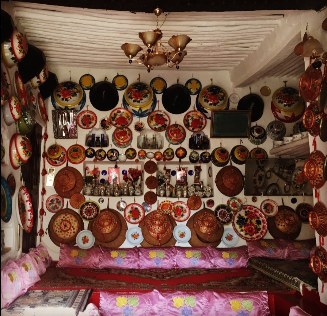 The ornaments on the wall are traditional Harari cultural items.On top of the door is a rack for a rolled up carpet.