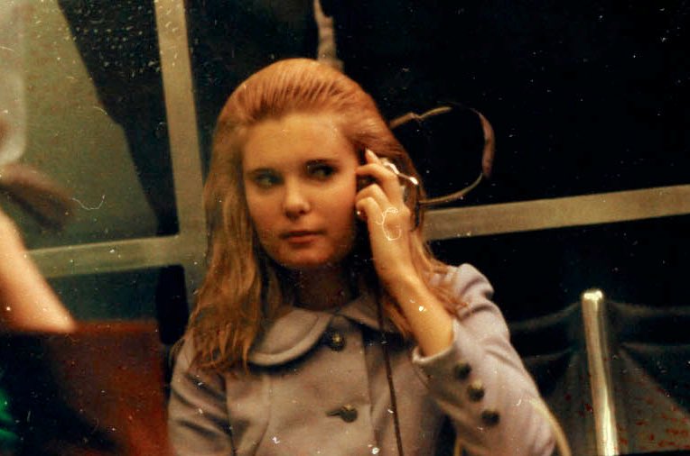 Her hair still very wet from the thunderstorm, Tricia Nixon follows the progress of the flight over a headset. 14/