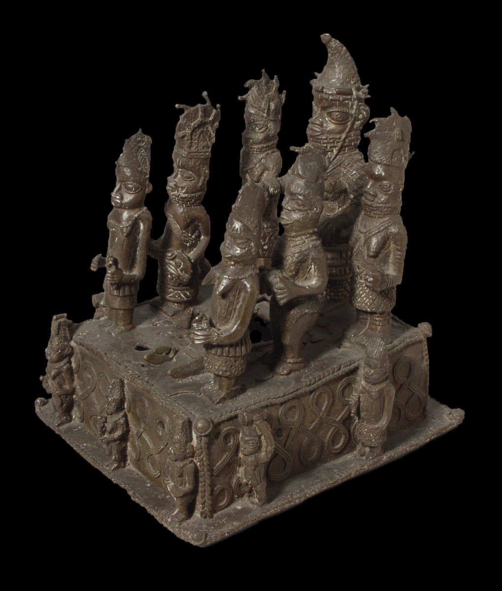 Cast brass altarpiece, with figures of a Queen Mother and six female attendants standing on top of a square base and smaller figures surround the base  #BeninDisplays  @Pitt_Rivers