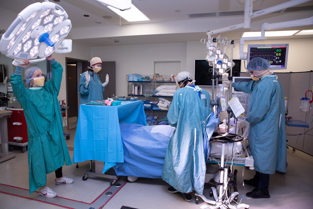 Four health care practitioners participating in a medical simulation in an operating room 