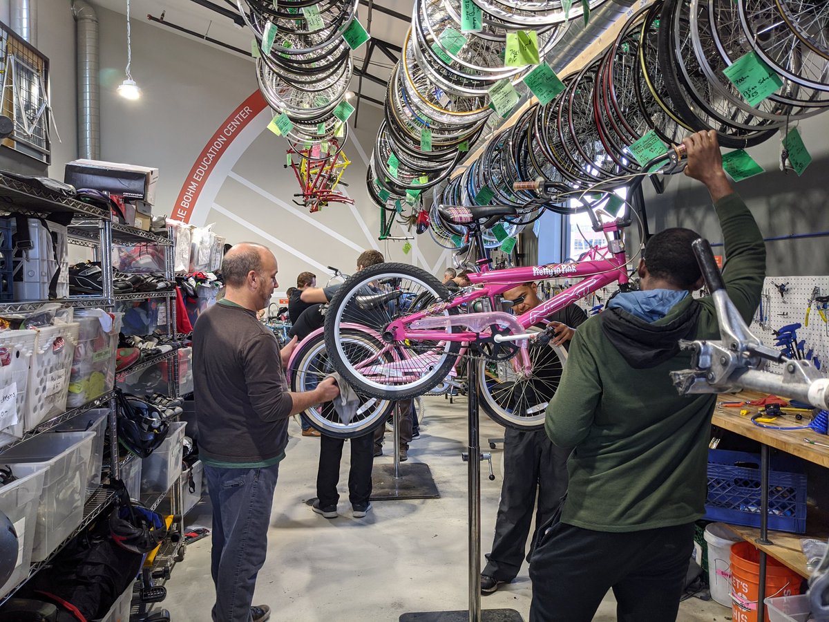 Group of volunteers repairing children's bikes.