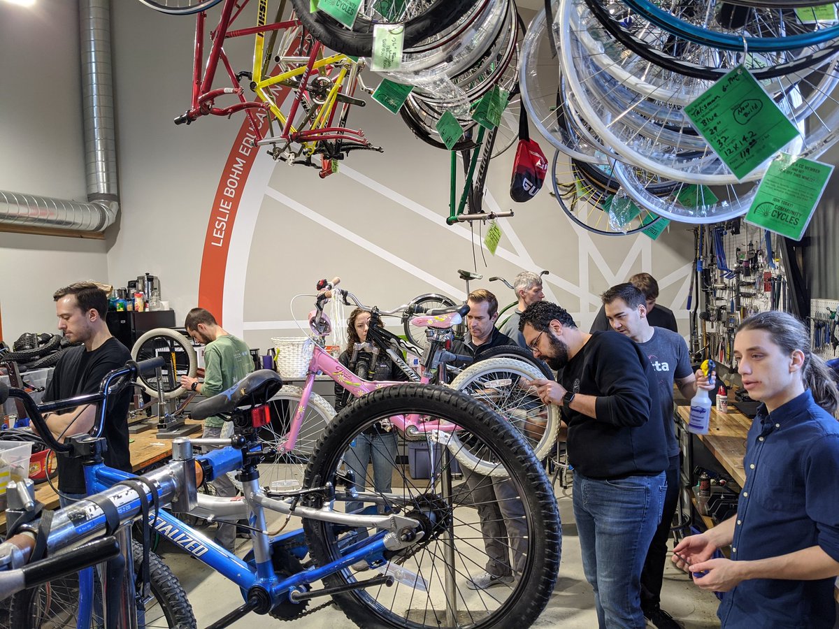 Group of volunteers repairing children's bikes.