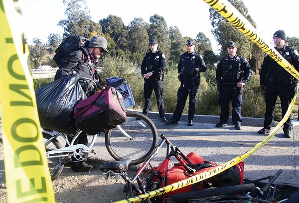 Santa Cruz Police clear homeless people and their belongings out of the former Camp Ross — know known as Camp Phoenix — on the corner of Highway 1 at River Street Friday.