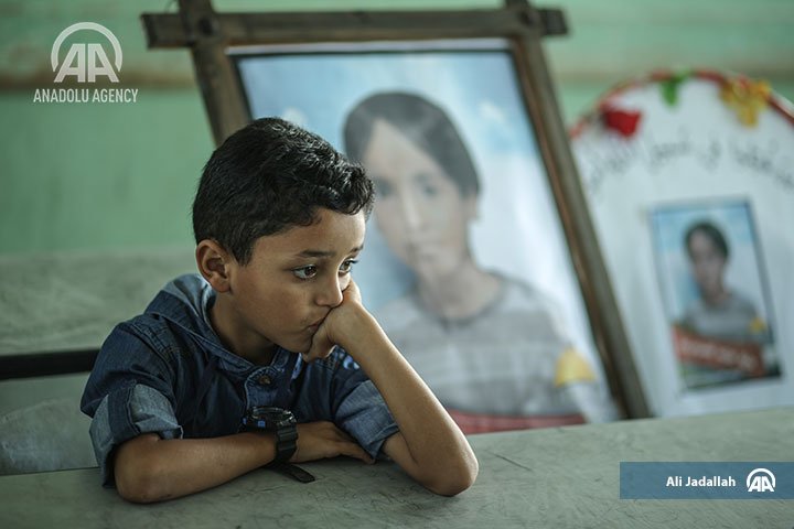 anadoluimages's tweet photo. A #student is seen at his #classroom as #photos of a #late #Palestinianstudent are placed near his #desk at #AbdullahIbnRawaha #elementaryschool, after 3 #Palestinian #students #lost their #lives in #Israel's recent #attacks over #GazaCity #Gaza #AA https://t.co/FzqwHgwpdY