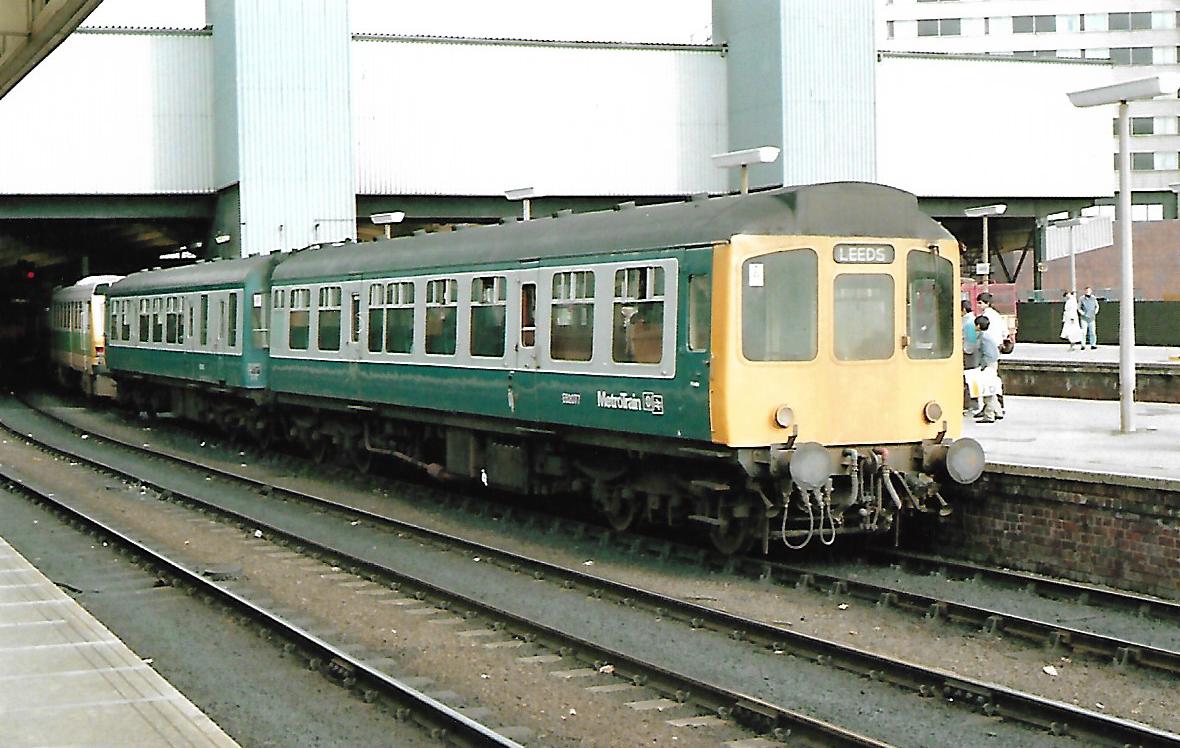 SalopianLyne's tweet photo. British Rail Class 110 Calder Valley 2 Car DMU with DMCL E52077 leading. Built by Birmingham RCW Ltd. in 1961. Pic'd at Leeds, Blue/Grey livery + WYPTE Metrotrain branding 14/7/86 with a Class 141 lurking behind. #BritishRail #DMU #Leeds #trainspotting #WestYorkshire #Class110🤓 https://t.co/mvvu8n5vyY