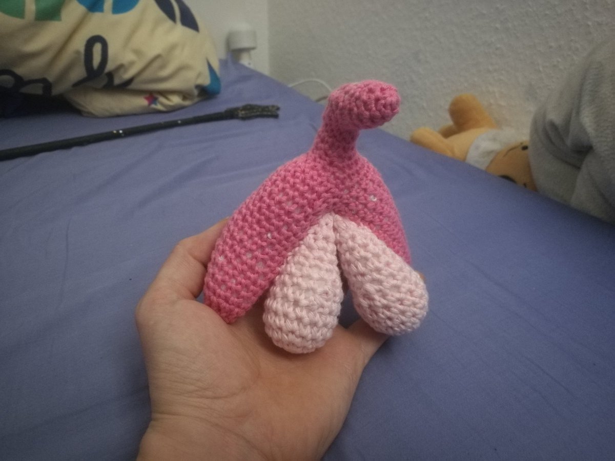 Plüsch Klitoris in meiner Hand. Sex toys im Hintergrund