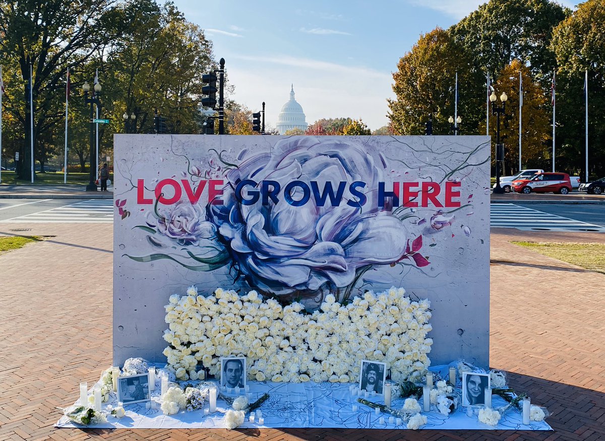 With the US Capitol as a backdrop, a large flower mural that reads “LOVE GROWS HERE” appears with images of victims of hate crimes.