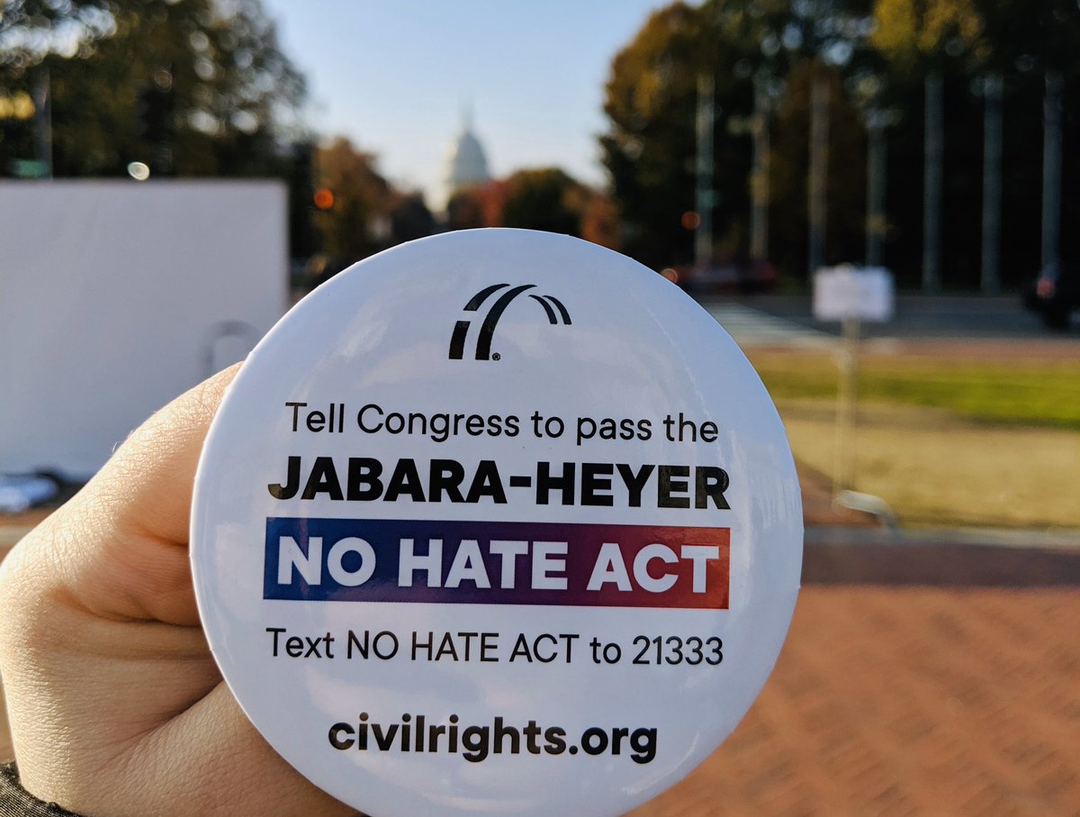 A button is held in front of the US Capitol that reads “Tell Congress to pass the Jabara-Heyer NO HATE Act. Text NO HATE ACT to 21333. civilrights.org”