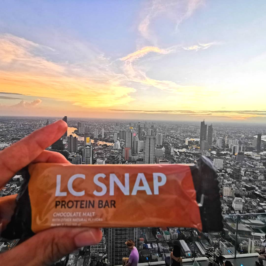 Unicity's tweet image. Narong enjoyed his LC Snap with a beautiful view of the city! Convenient, tasty, high-quality protein when you're on the go. Where do YOU enjoy your LC Snap protein bars? 🍫📸: @narong.mr 
#UnicityisMe #LCSnap #Unicity #PrioritizeProtein