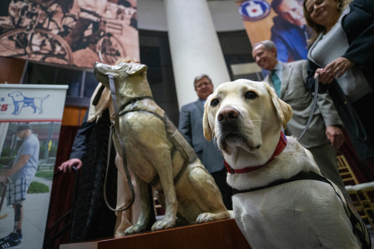 Sully H.W. Bush standing beside his statue replica at the Bush Library