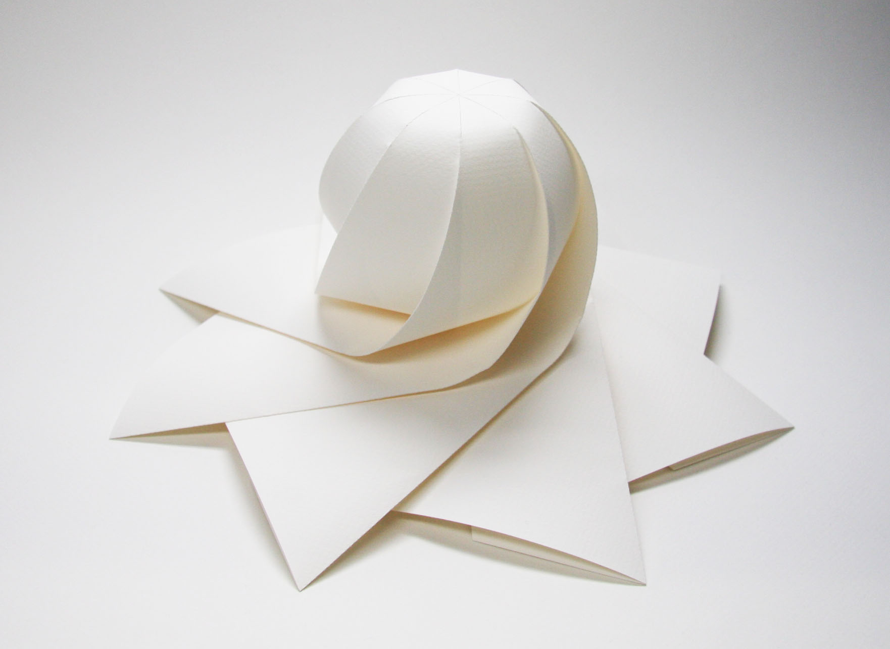 三谷 純 Jun Mitani 立体を紙で包むときに 長方形の紙で側面を覆うのではなくて 正多角形の紙で上から被せるようにして覆うアプローチも考えられます チュッパチャップスの包装紙みたいな感じです そんな発想で こちらの形が作り出されました 1つ