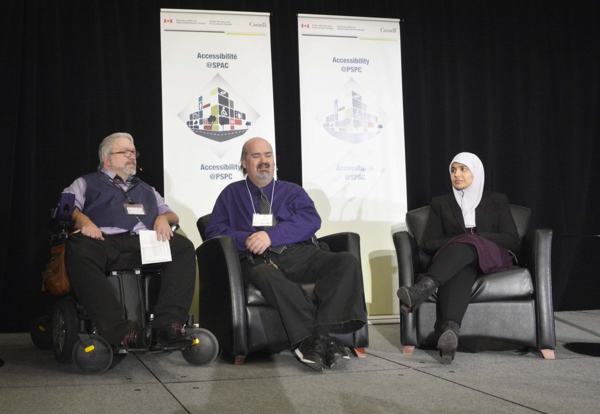 Two men and one woman on the stage during the panel.