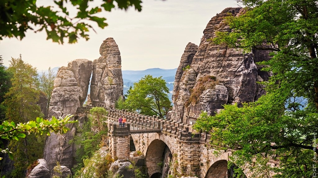 ドイツ観光局 まるで巨人が造ったかのような奇景が連なる ザクセンスイス国立公園 古都ドレスデンからわずか30kmの場所で こんな異次元の風景が楽しめるんです 中でも 山頂の岩と岩をつなぐバスタイ橋は 天空の橋 と呼ぶにふさわしい大迫力の絶景