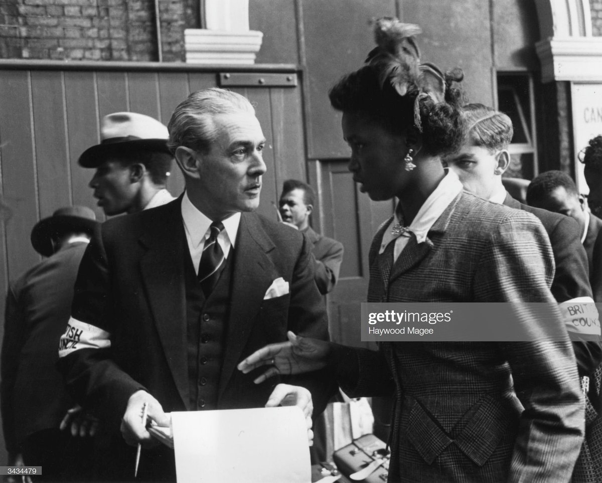 A British Council worker talking to a newly arrived lady at Victoria Station, London, 1956. Photo by Haywood Magee