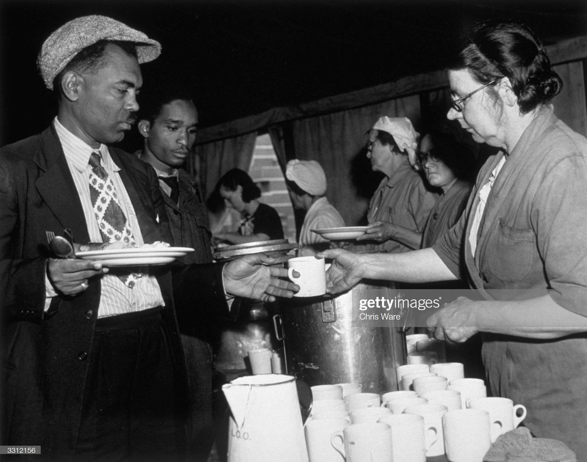 Jamaican immigrants collect a meal from the canteen set up for them at a hostel in the Clapham air raid shelter, south London, July 1948. Photo by Chris Ware