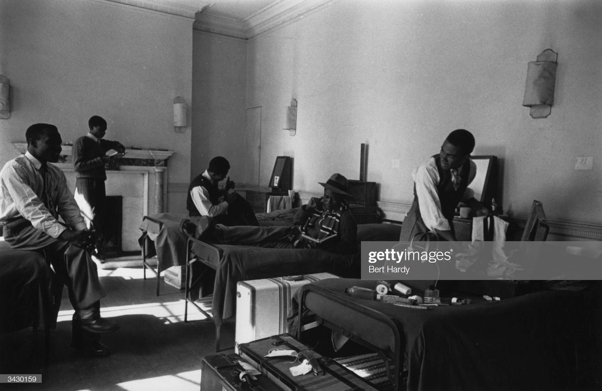 A group of recent arrivals unpack their luggage in a shared room in a hostel, 1949. Photo by Bert Hardy