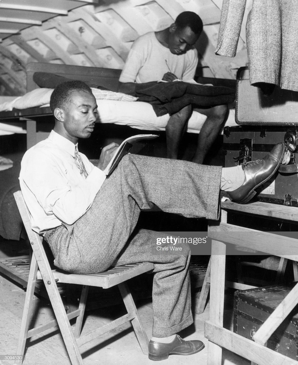 Charles Stimson (foreground) and Charles Baker writing home to Kingston, Jamaica from a converted air-raid shelter on Clapham Common. It is being used as temporary reception centre for immigrants arriving in London to help out with the labour shortage, 1948.Photo by Chris Ware