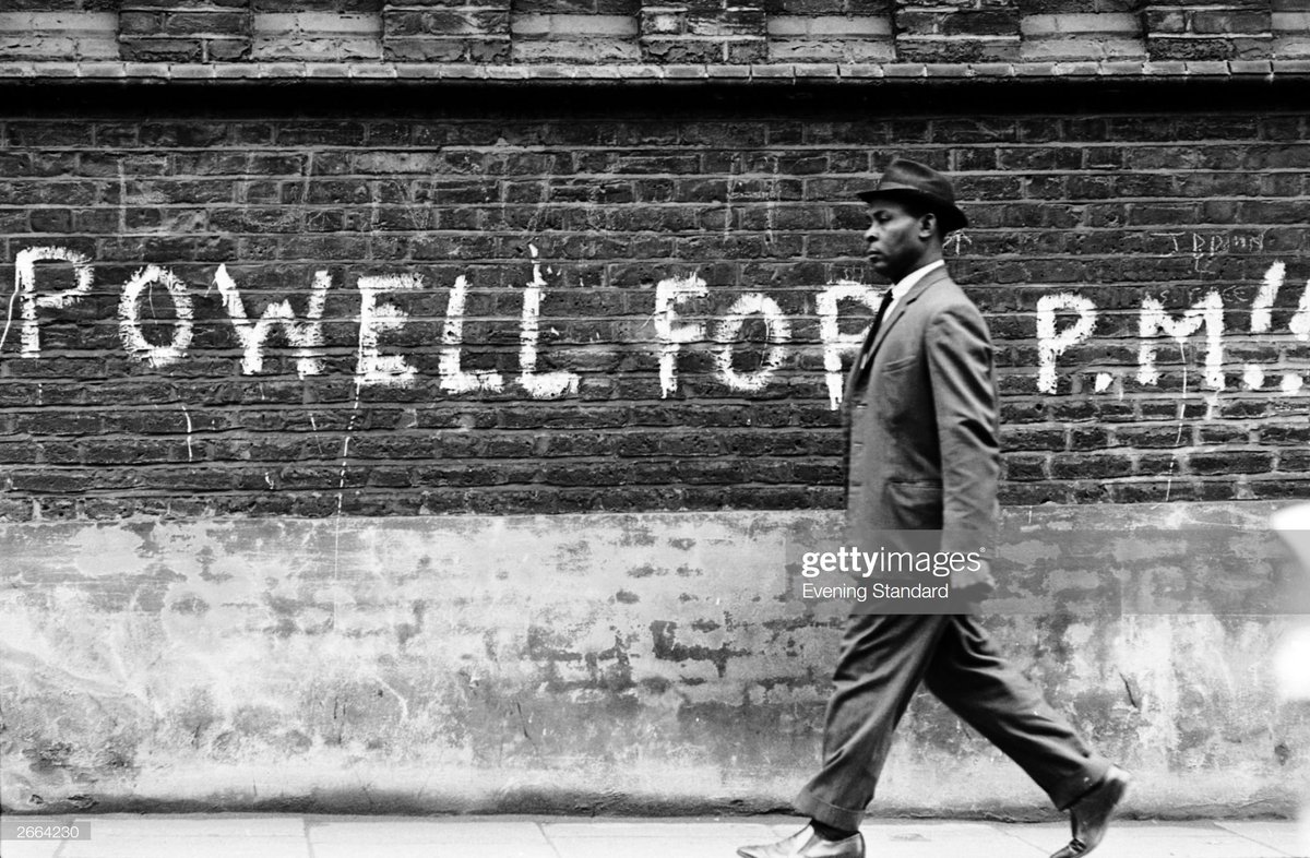 A man walking past graffiti stating 'Powell For PM', referring to Tory politician Enoch Powell who caused controversy with his outspoken attitude to immigration and racial integration culminating in his infamous 'Rivers of Blood' speech.Photo by Evening Standard