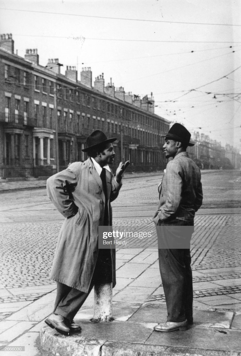 Two West Indian immigrants talking on a Liverpool street corner, 1949. Photo by Bert Hardy