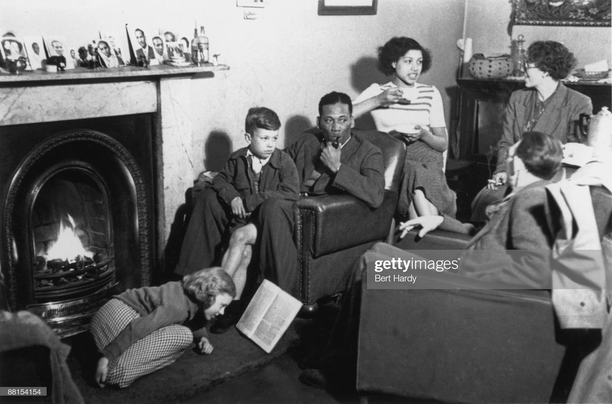 Neighbours visiting a West Indian couple at home, 1949. Photo by Bert Hardy