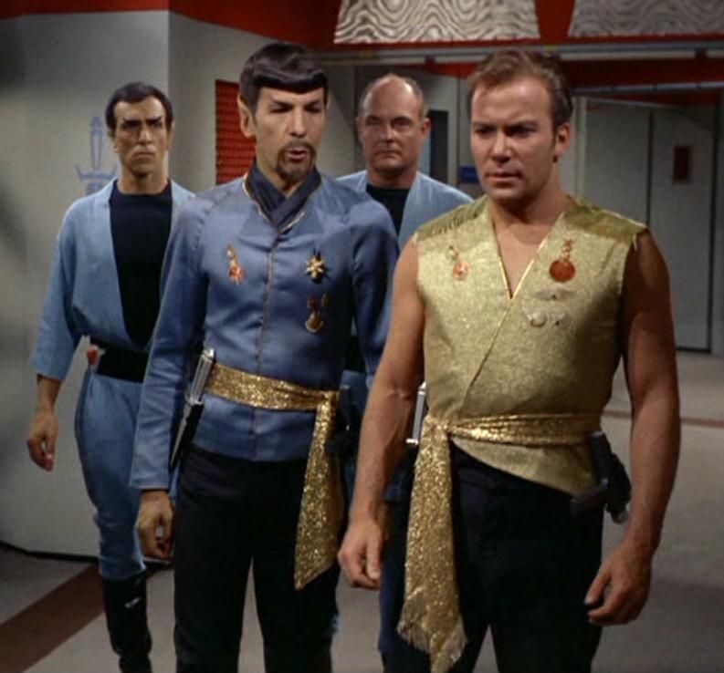 Here is a glimpse at the Mirror Universe uniforms.Sleeveless bold Kirk with sash and blade, Spock in a more Nehru jacket minus the buttons look and the utilitarian coveralls. Lots of sexiness here in the guys, for a change