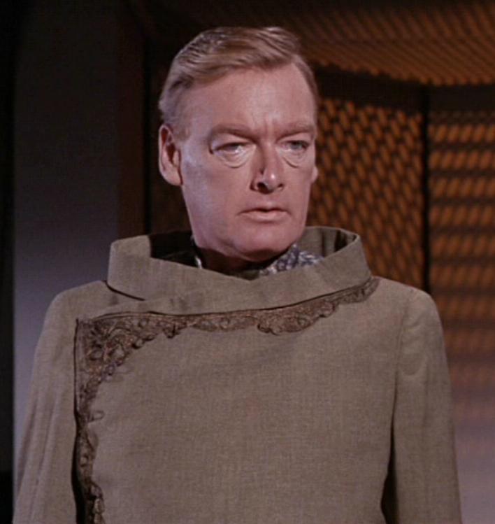 Ambassador Fox is not in Star Fleet, but he is a Federation official, a sort of State Department civil servant.While horribly bland earth tone, its not a bad outfit. In fact, its got similarities to the Wrath of Khan uniforms