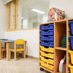 Sala de lleure per infants amb cadires de colors.