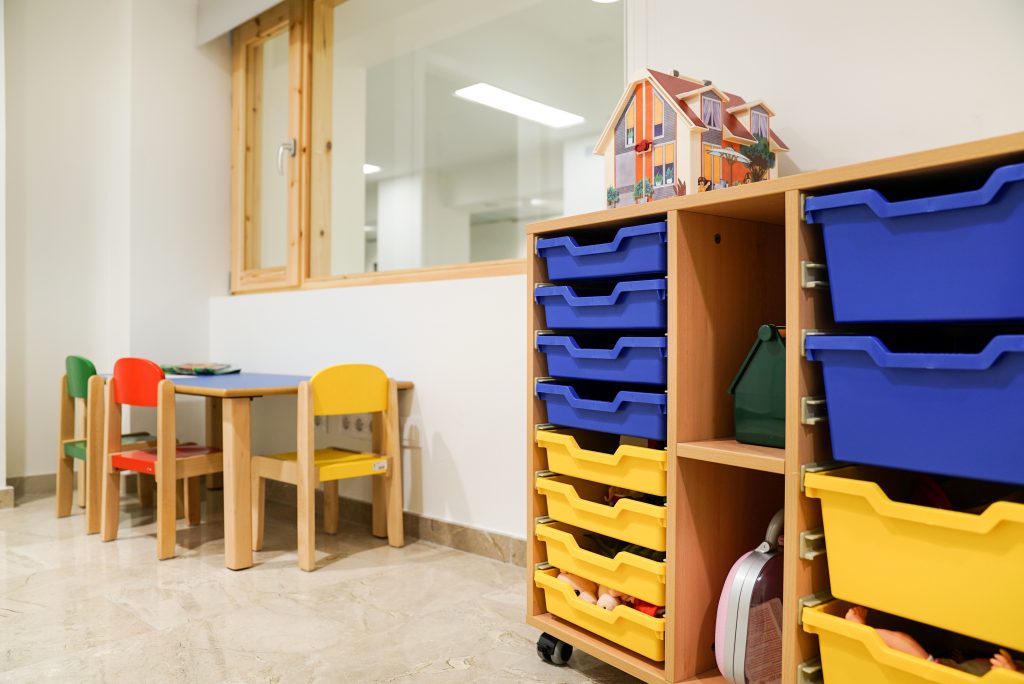 Sala de lleure per infants amb cadires de colors.