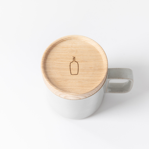 A photo that includes coffee cup, cup, and wood from Blue Bottle