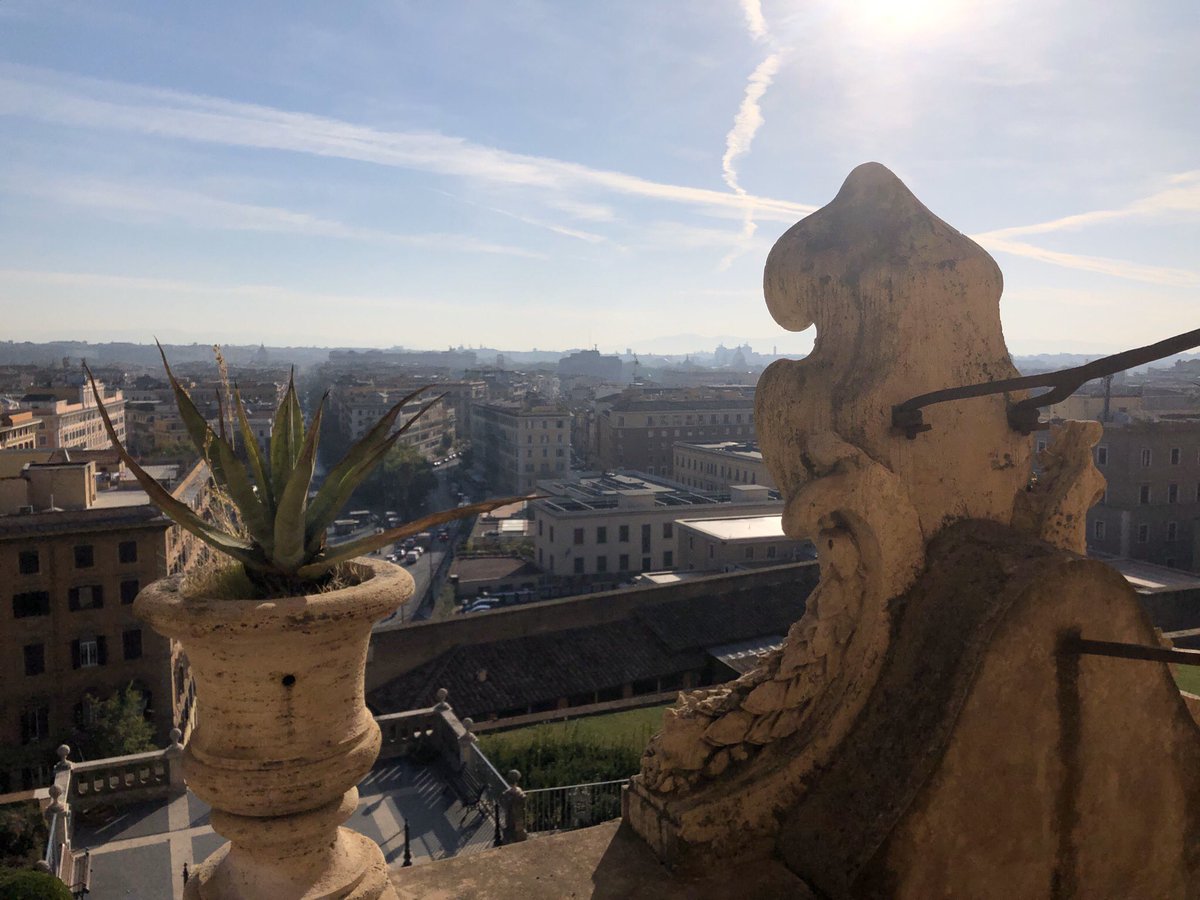 The outside balcony of The Vatican Museum. It brilliantly shows a glorious view of the city of Rome, & it is nicely accompanied by the plants that reside within the flower pots made out of stone, while The Sun shines greatly above. How relaxing.