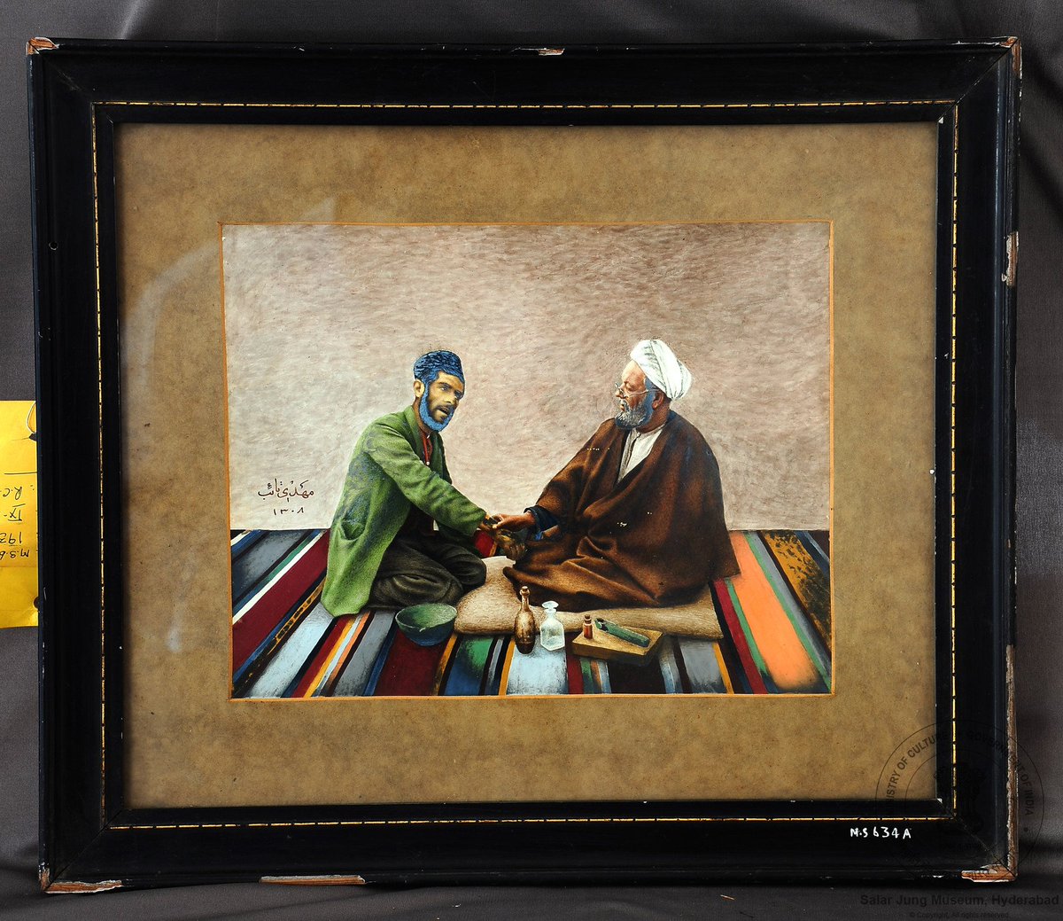 sjmhyd's tweet photo. Water colour painting fitted in a black frame; representing a ‘’hakim’’ (Unani doctor) examining a patient, both seated on a striped ‘’dari’’ or rug, India, 20th century.

#20thcenturyArt
#SalarJungMuseum
#hakim https://t.co/S73soLi1LI