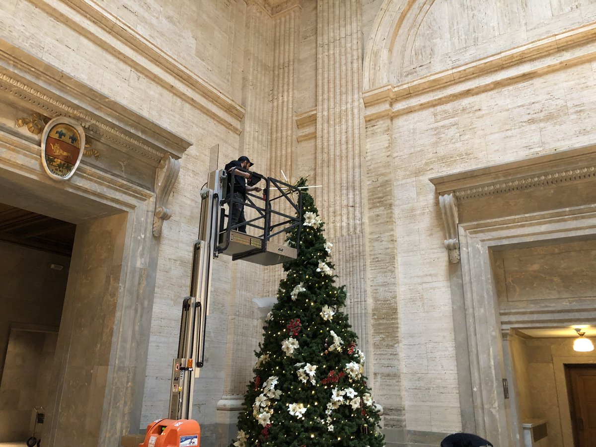 Another irony: as arguments continue, workers in foyer of courthouse affix star to the top of Christmas tree