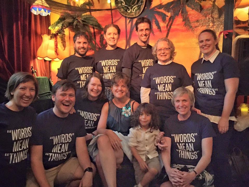 A group of people wearing shirts that say “words” mean “things”