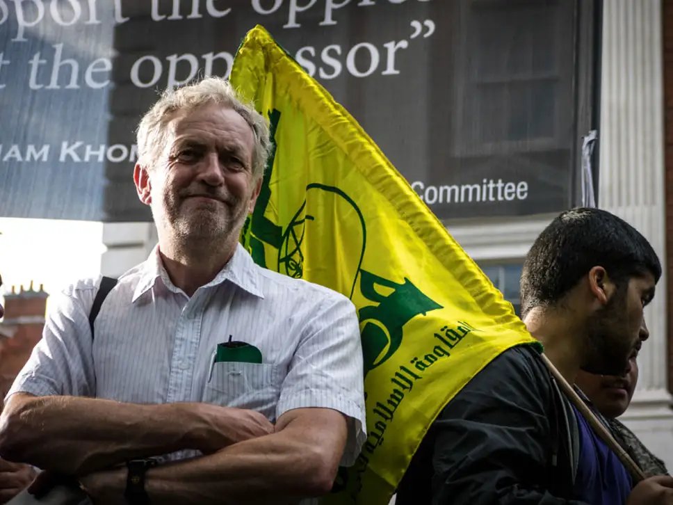 In 2012, Corbyn spoke at Al Quds Day (pictured joining with Hamas supporters, an organisation which called to "annihilate Jews" and said "the Holocaust is still to come upon the Jews") in support of Mahmoud Ahmadinejad's fight against the "Zionist black stain".