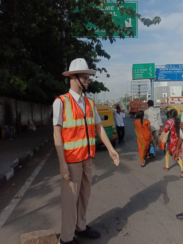 BLRNews_com's tweet photo. Short of staff, #Bengaluru traffic police use mannequins to curb violations in the City. The dept plans to install 200 dummy models on busy intersections.

As of now, there are 5,000 traffic police personnel, managing around 888 signals. 

B’luru has over 44,000 intersections. https://t.co/rQUiJgyKHI
