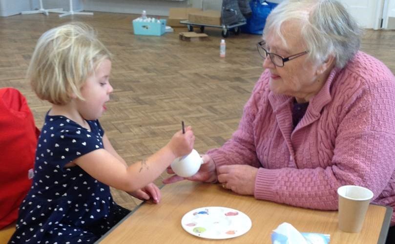 We run weekly sessions at St Catherine’s Court in Bedminster, working to reduce isolation &amp; loneliness.
Today the residents had an outing to the Southville Centre to meet with children from our Raleigh Room nursery and they enjoyed working in pairs to decorate Christmas baubles.