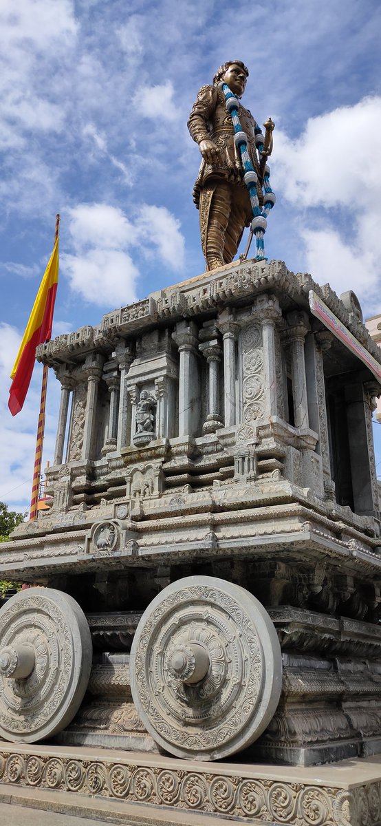 #Bengaluru 
Blue sky,  naada dwaja and Annavru <3

Rajkumar's bronze statue on stone chariot at Kurubarahalli in MahalakshmiLayout #SanchaariChitra