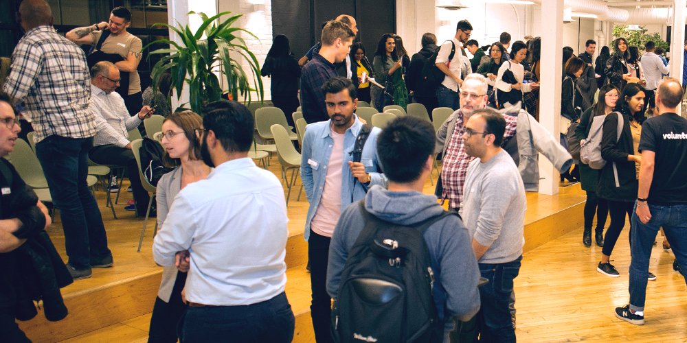 Many people standing around and chatting with each other during the first Design Systems Community meetup at Shopify.
