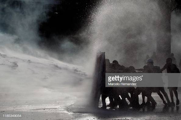 Protest and picket for your rights! #Stolen <a href="/GettyImages/">Getty Images</a> Demonstrators protect themselves from water fired by riot police during a protest against President of #Chile