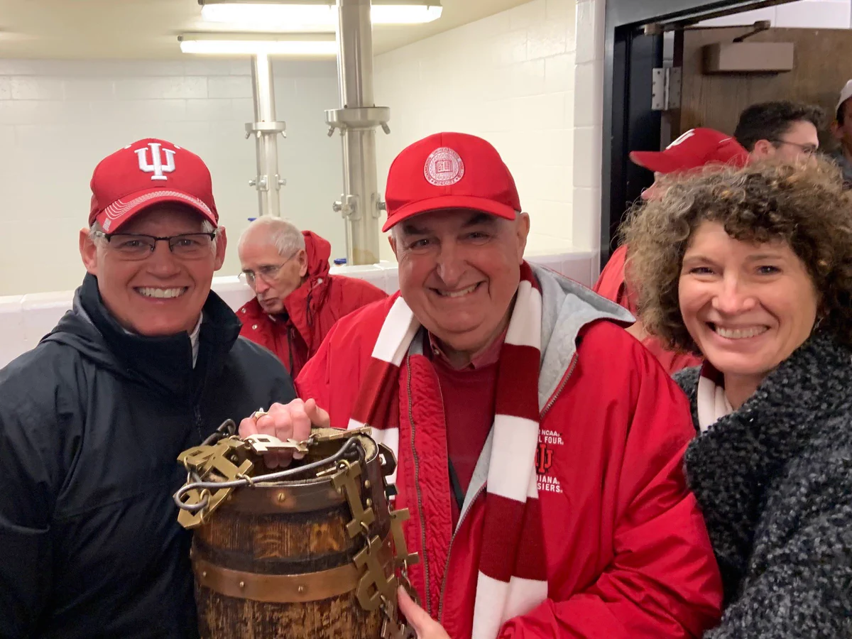 Coach Tom Allen with President McRobbie and First Lady McRobbie holding the Old Oaken Bucket.
