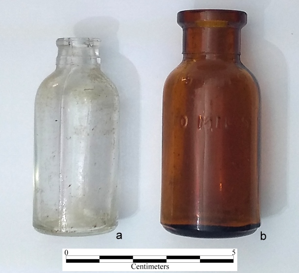 Shot common historic medicine bottles found on rural sites in the US, most likely for veterinary purposes. a) 10 ml Owens-Illinois Glass Co. Duraglas syringe bottle. This had a rubber seal w/ crimped metal cap. A syringe needle would pierce the rubber seal to extract the med. 1/