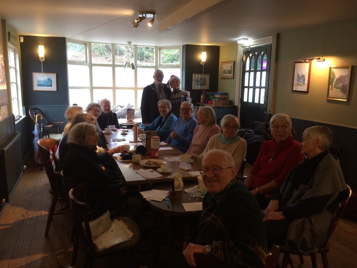 Elderly people sitting around a table in a pub