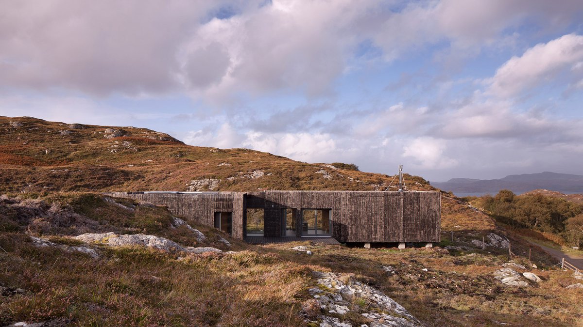 See inside this house clad in burnt larch perches on a rocky site in the Scottish Highlands: at.dezeen.com/2RWundt