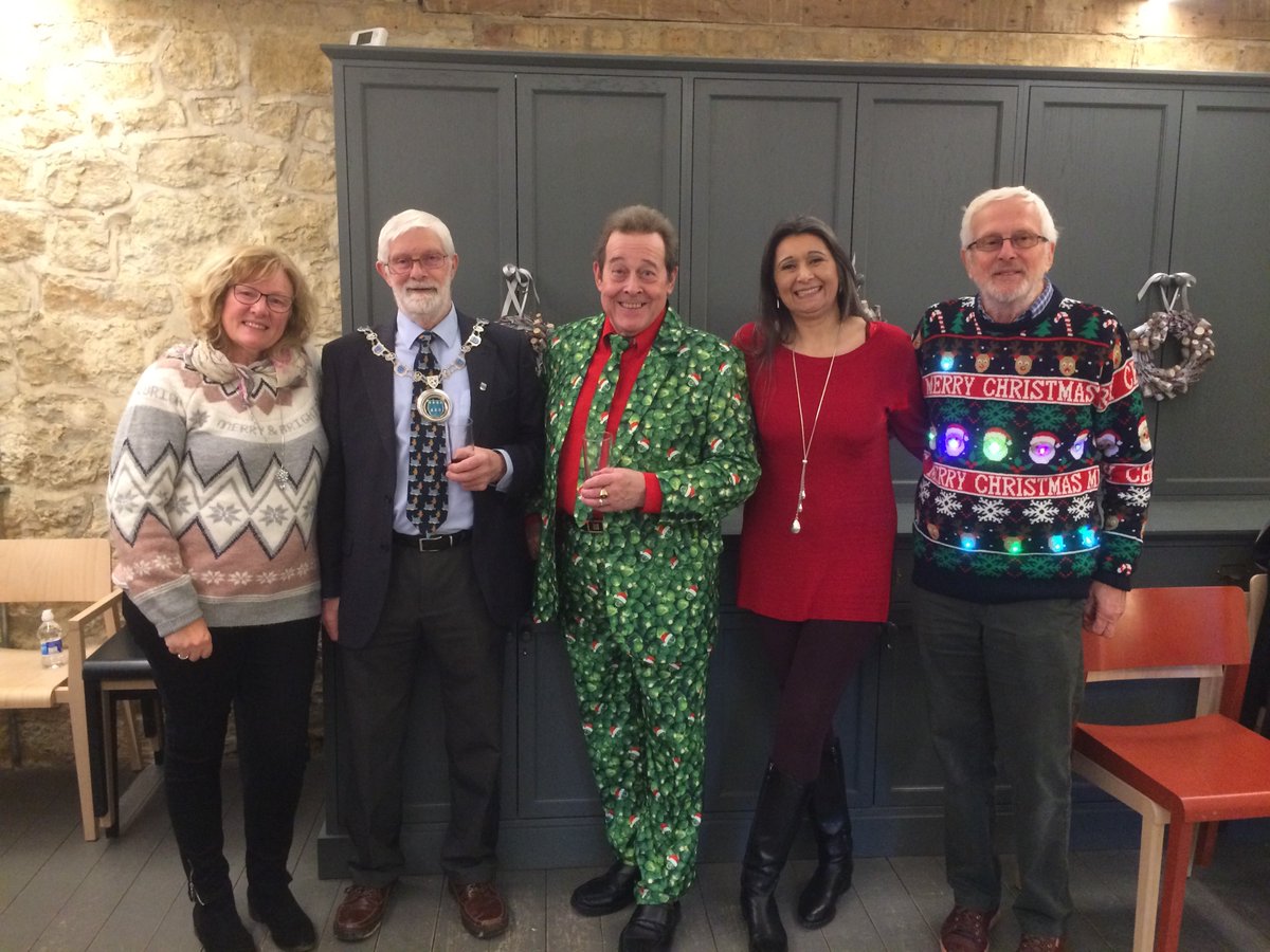 Five people smiling in Christmas jumpers