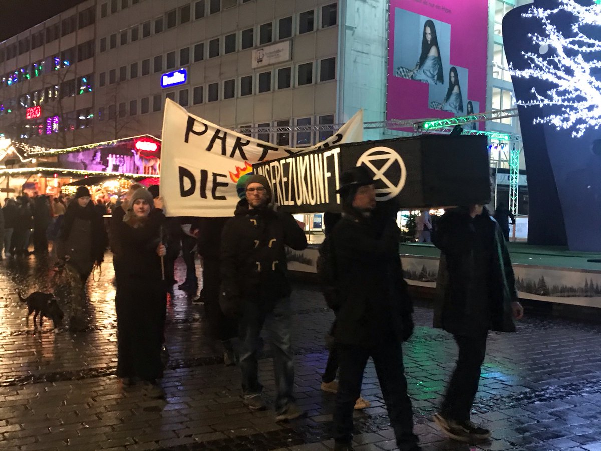 XR_Duisburg's tweet photo. Um auf den Widerspruch zwischen vorhandenem Bewusstsein für den #Klimawandel &amp; der mangelhaften Bereitschaft für mehr #Klimaschutz in Politik &amp; Teilen d. Gesellschaft aufmerksam zu machen, trugen wir am Samstag unsere Zukunft bei Partymusik über den Weihnachtsmarkt zu Grabe. https://t.co/OAFlW62Moc