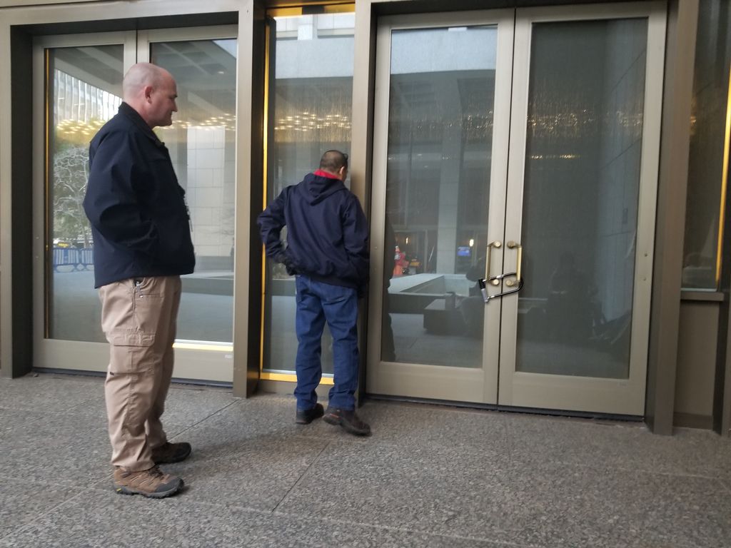 two guards examine a u-locked door